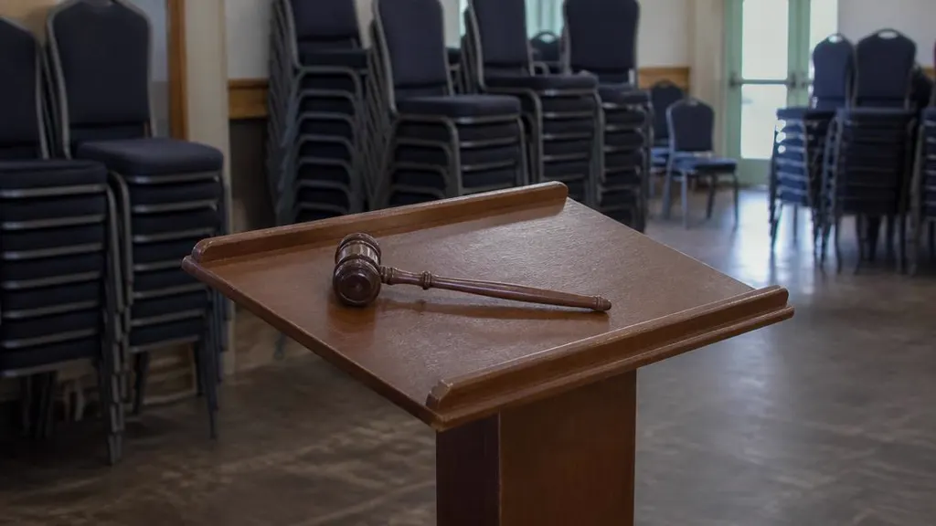 Auctioneer's gavel on an empty lectern after the sale, chairs stacked behind