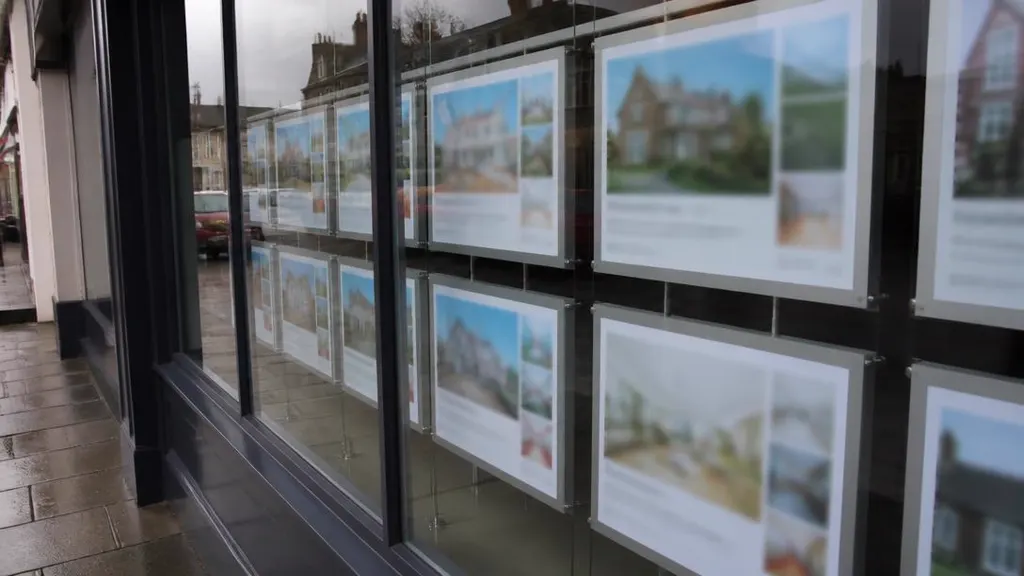 Estate agent window display of property cards seen from the pavement