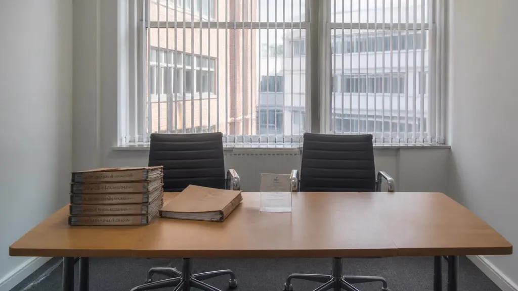 Empty solicitor's meeting room with court bundles stacked on the table