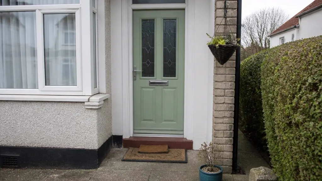 Front door of an ordinary semi-detached house seen from the path